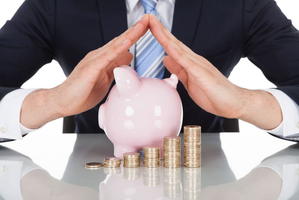 A man next to a piggy bank and money