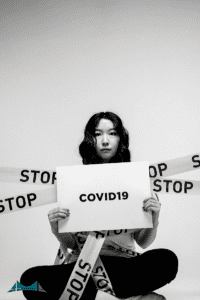 A women holding a sign that says "Covid 19"